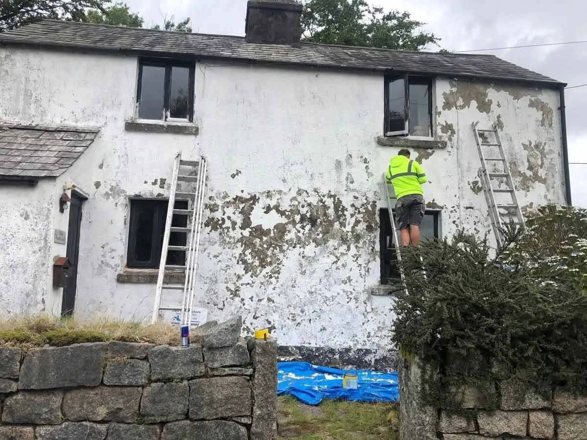Cottage with blown, flaking render before repair in Polzeath
